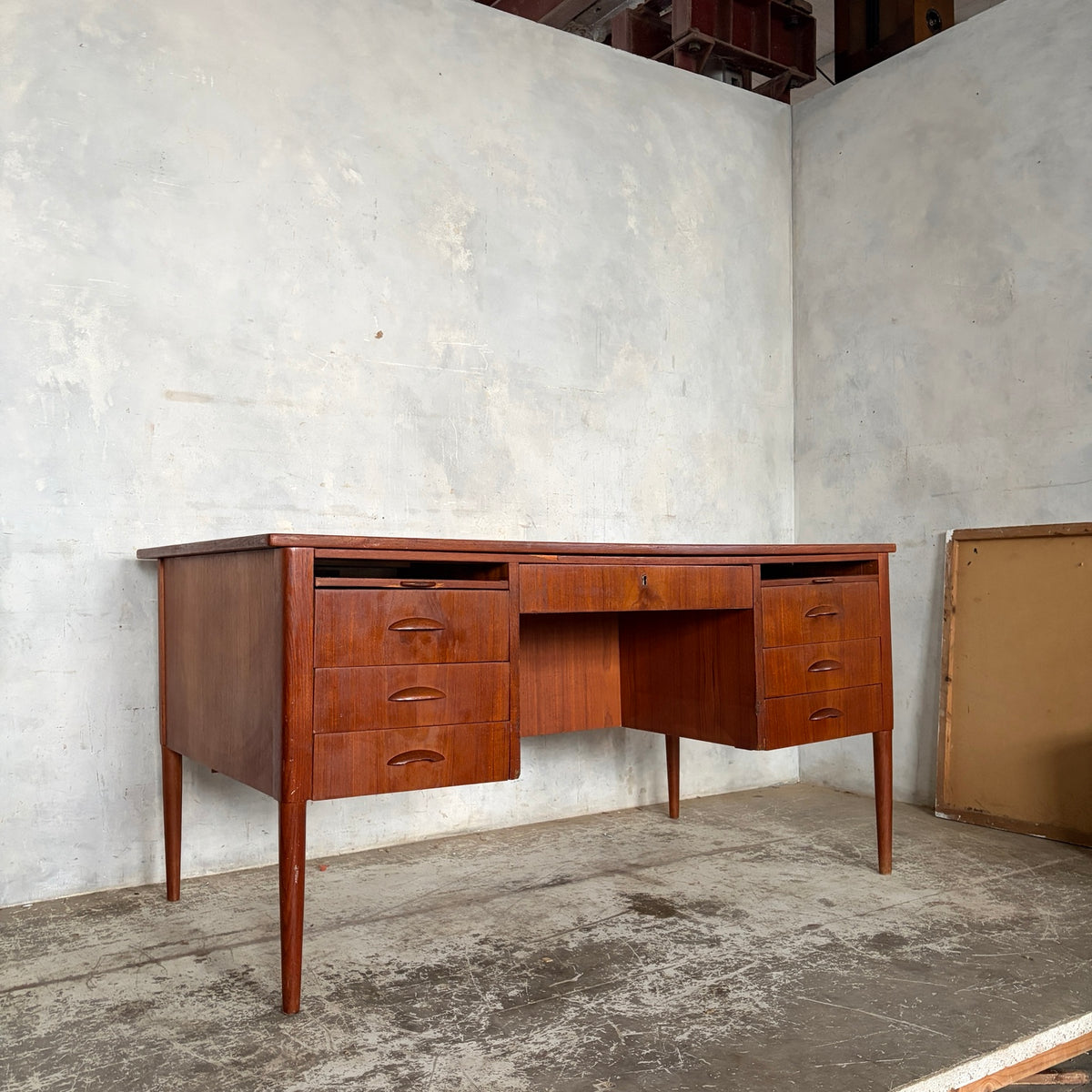 Mid-century twin pedestal desk showing drawers and tapered legs