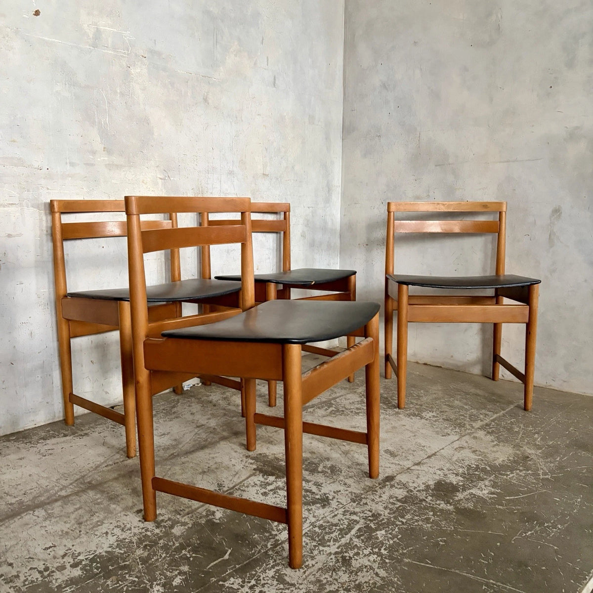 Set of four mid-century teak and beech dining chairs with black vinyl seats – view 1